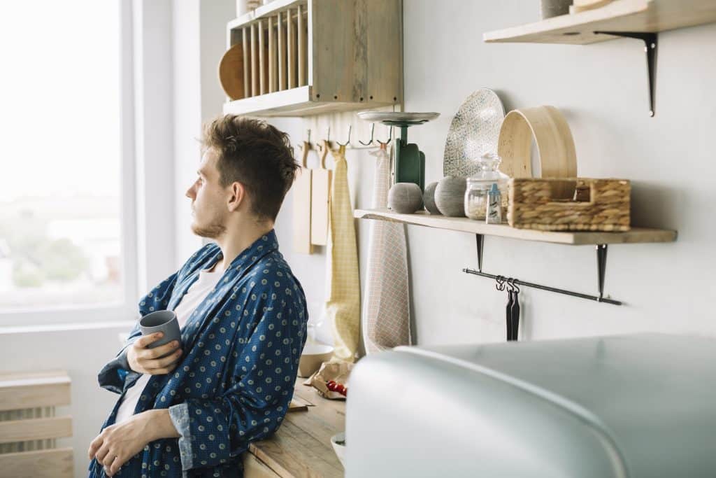man standing in his crowded kitchen